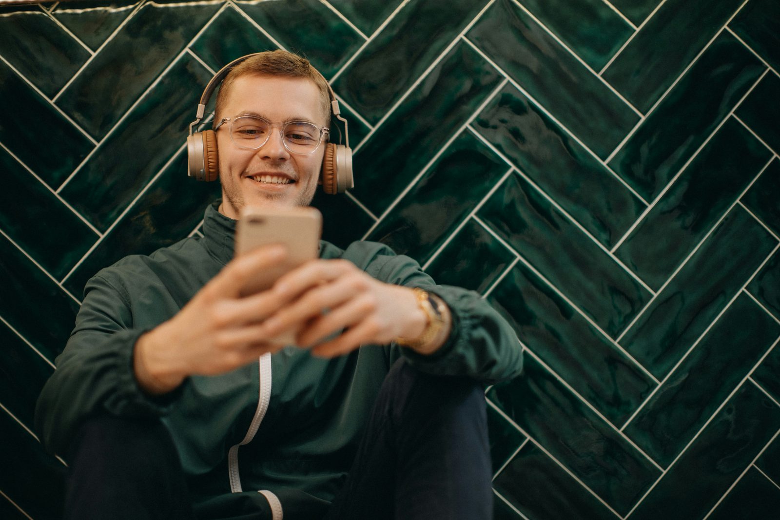 Muž se sluchátky kontroluje audit v telefonu